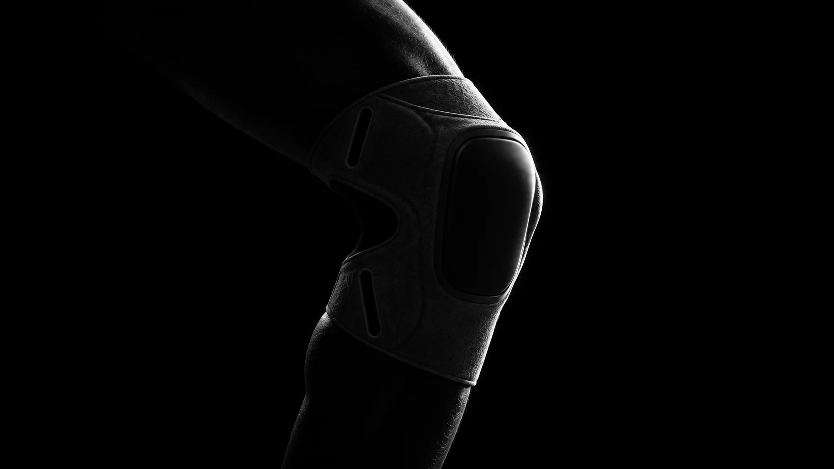 A bent knee in near darkness, wearing the sleeve.